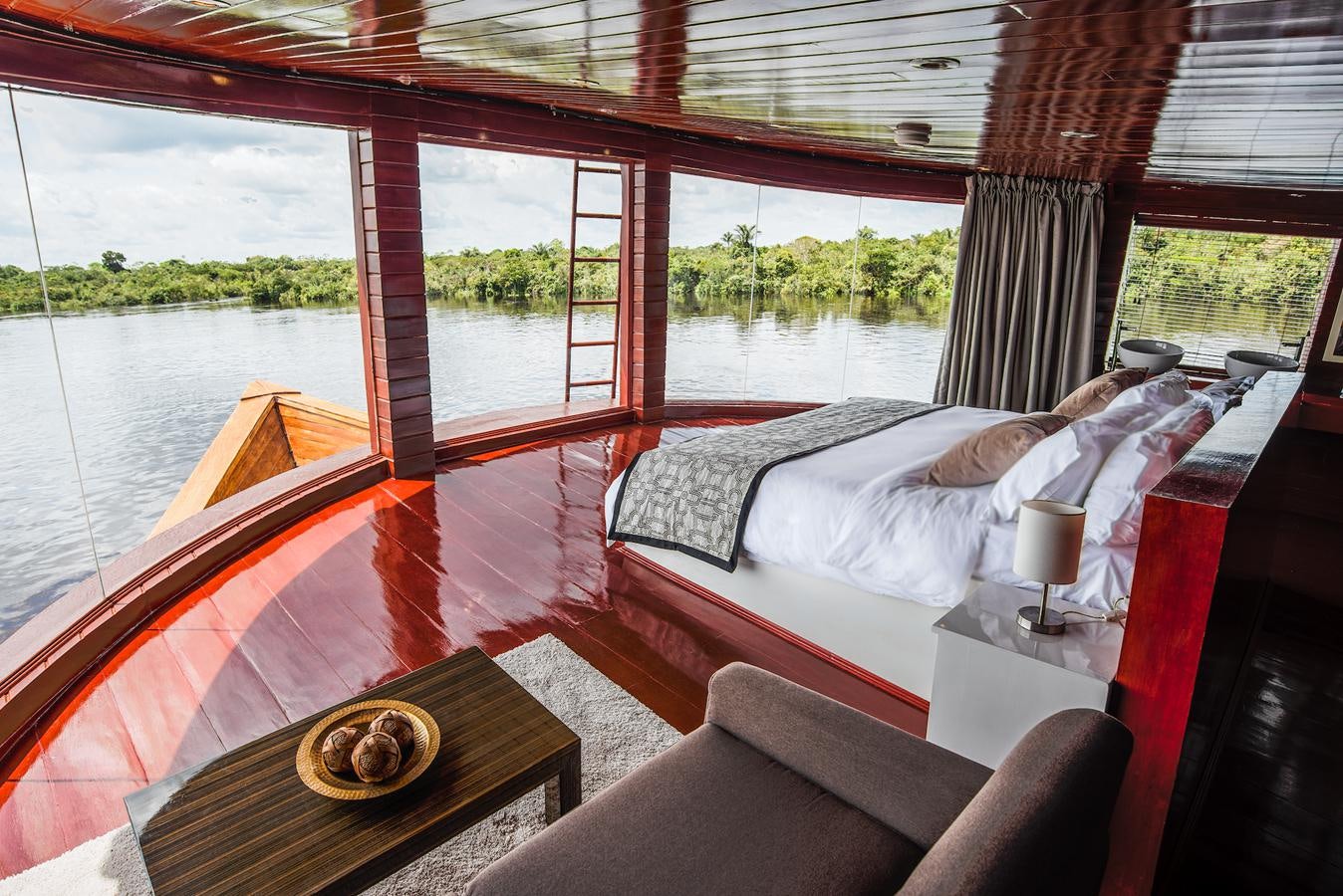 a room with a bed and a table aboard CRUCERO AMAZONAS Yacht for Sale