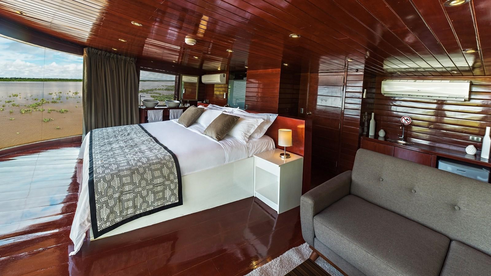 a room with a bed and a couch aboard CRUCERO AMAZONAS Yacht for Sale