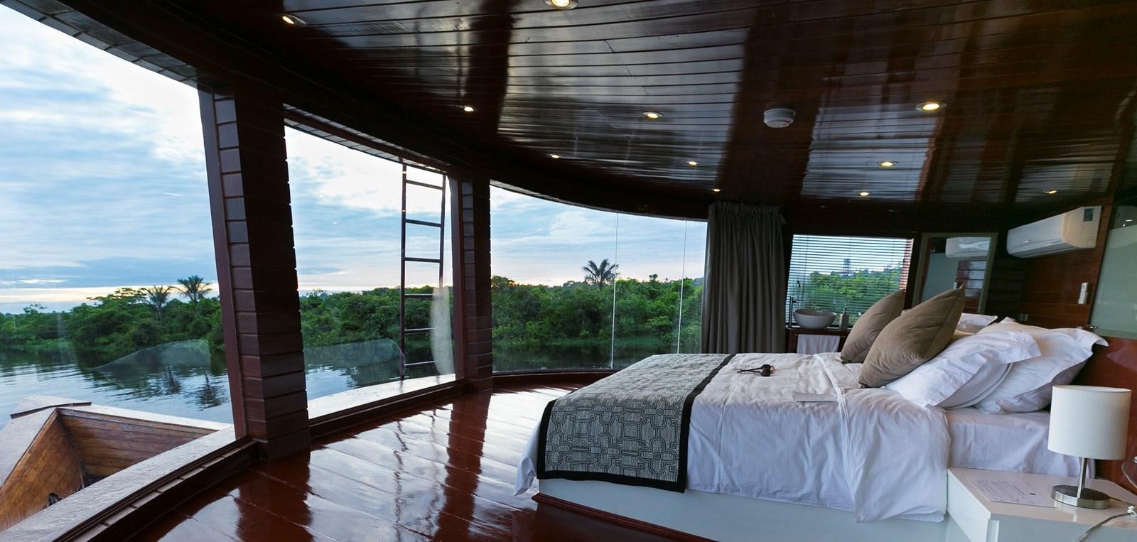a room with a bed and a window aboard CRUCERO AMAZONAS Yacht for Sale