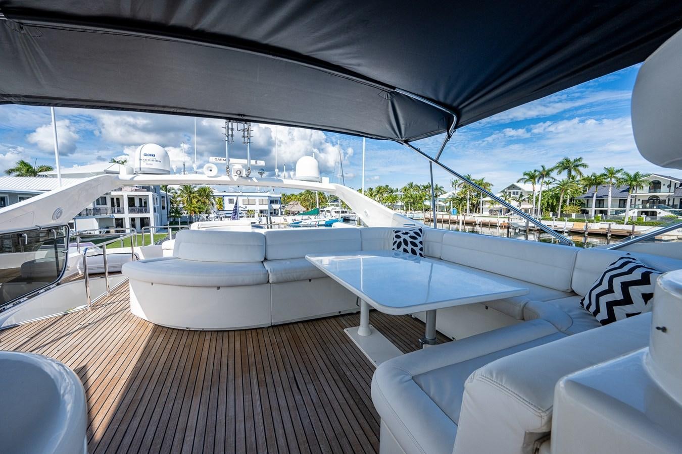 a deck with a large white tent and a deck with chairs and a pool and trees aboard EVERYTHING GOOD Yacht for Sale