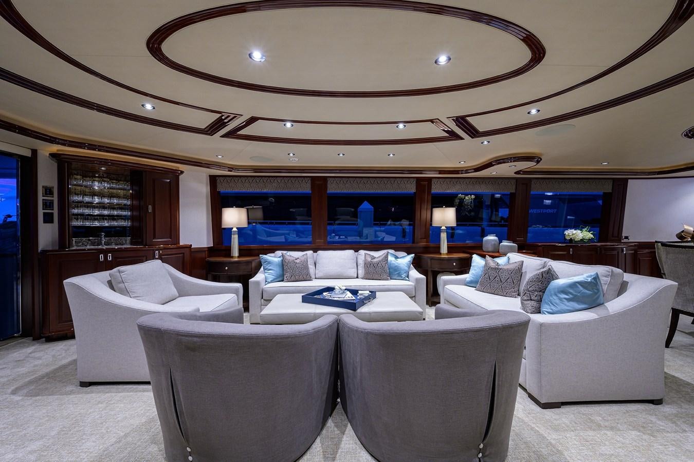 a large living room with a large mirror above the couch aboard TIRELESS Yacht for Sale