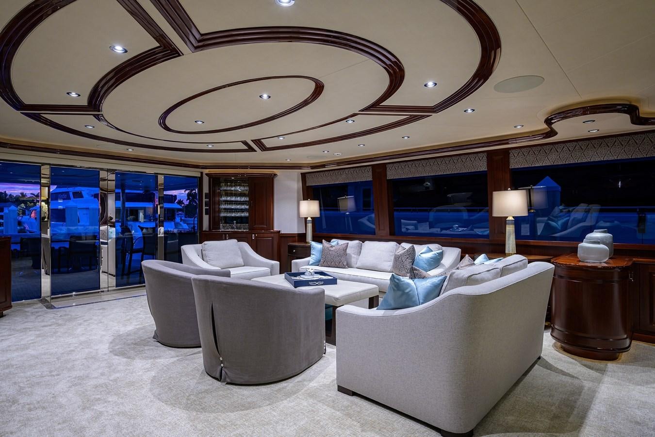 a large room with couches and a large chandelier aboard TIRELESS Yacht for Sale