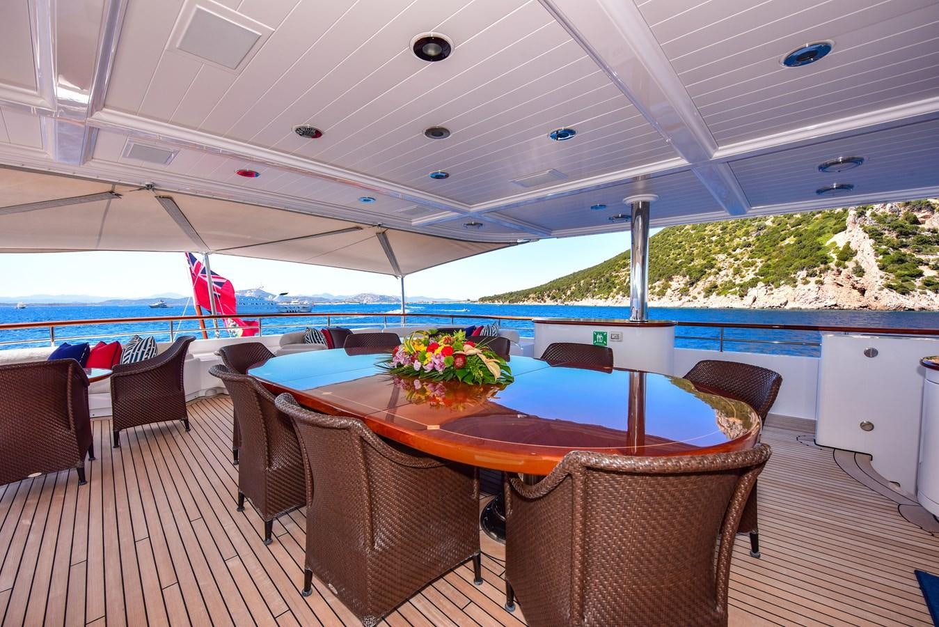 a large outdoor patio with a table and chairs and a pool aboard BERILDA Yacht for Sale