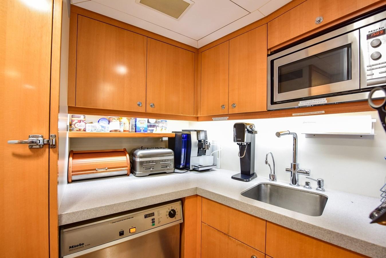 a kitchen with wooden cabinets aboard BERILDA Yacht for Sale