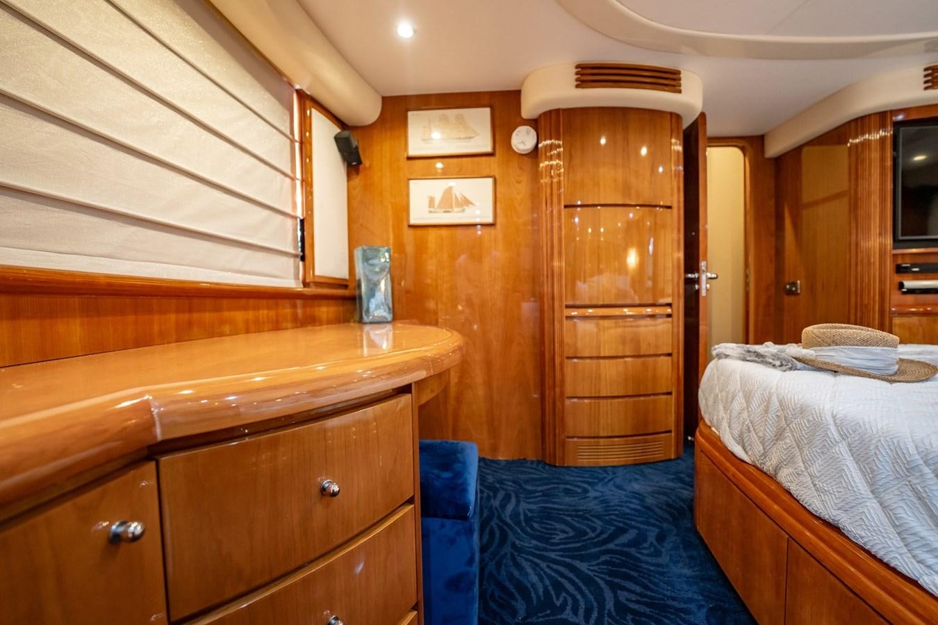 a bedroom with wooden cabinets aboard GET WET Yacht for Sale