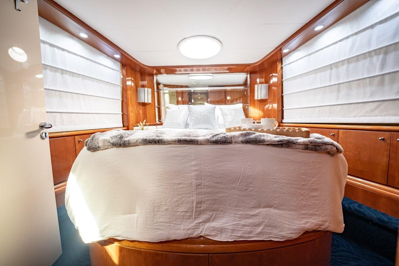 a bed with a wooden frame aboard GET WET Yacht for Sale