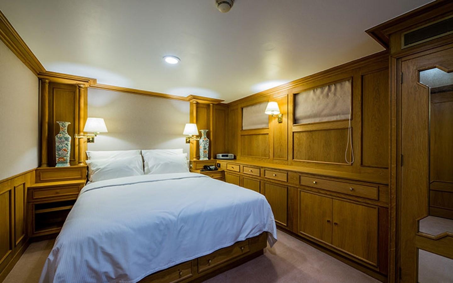 a bedroom with a bed and a desk aboard NOSTALGIA Yacht for Sale
