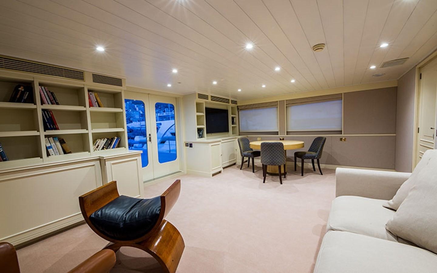 a room with a table chairs and a couch aboard NOSTALGIA Yacht for Sale