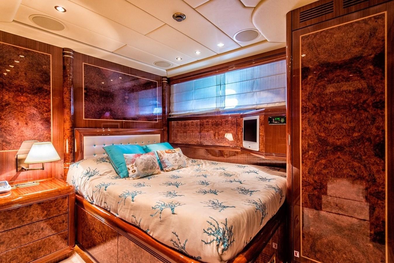a bedroom with a bed and a fireplace aboard PHANTOM Yacht for Sale