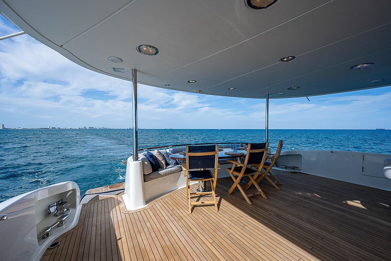 a deck with chairs and a table on it aboard LAZZARA 116 OPEN BRIDGE Yacht for Sale
