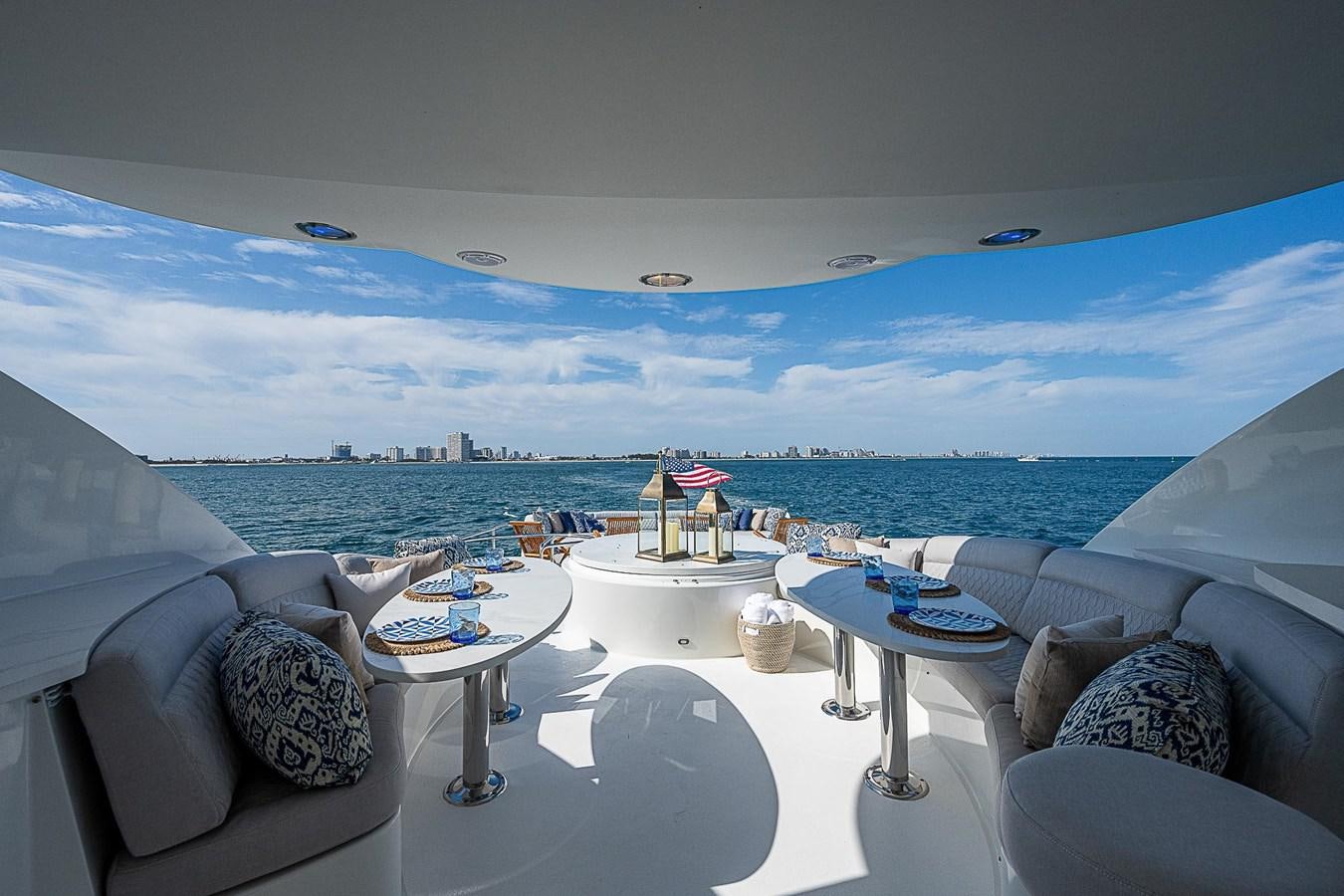 a room with a couch and a table and chairs and a large body of water aboard LAZZARA 116 OPEN BRIDGE Yacht for Sale