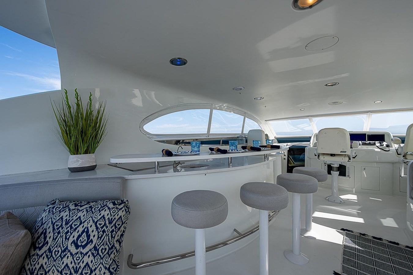 a room with stools and a table and chairs aboard LAZZARA 116 OPEN BRIDGE Yacht for Sale