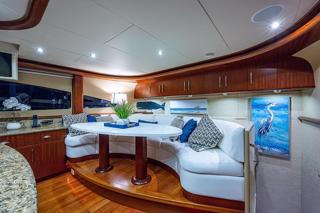 a room with a table and a couch aboard LAZZARA 116 OPEN BRIDGE Yacht for Sale