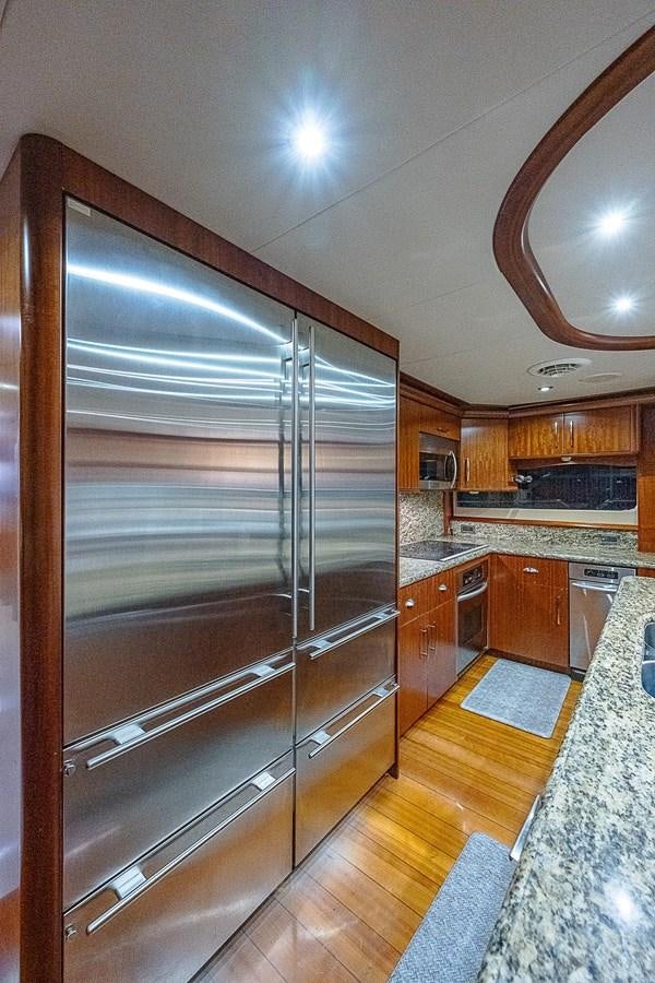 a large kitchen with wooden cabinets aboard LAZZARA 116 OPEN BRIDGE Yacht for Sale