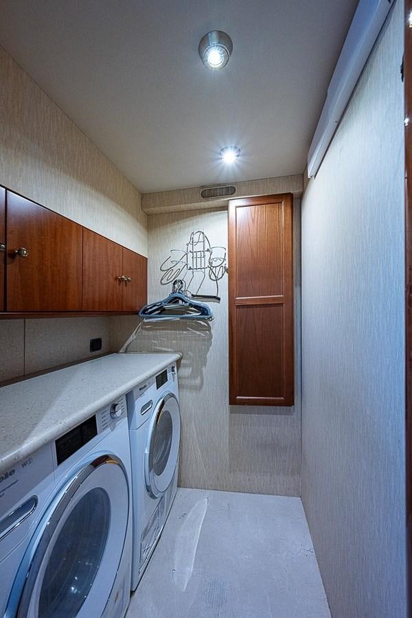 a small kitchen with a washing machine aboard LAZZARA 116 OPEN BRIDGE Yacht for Sale