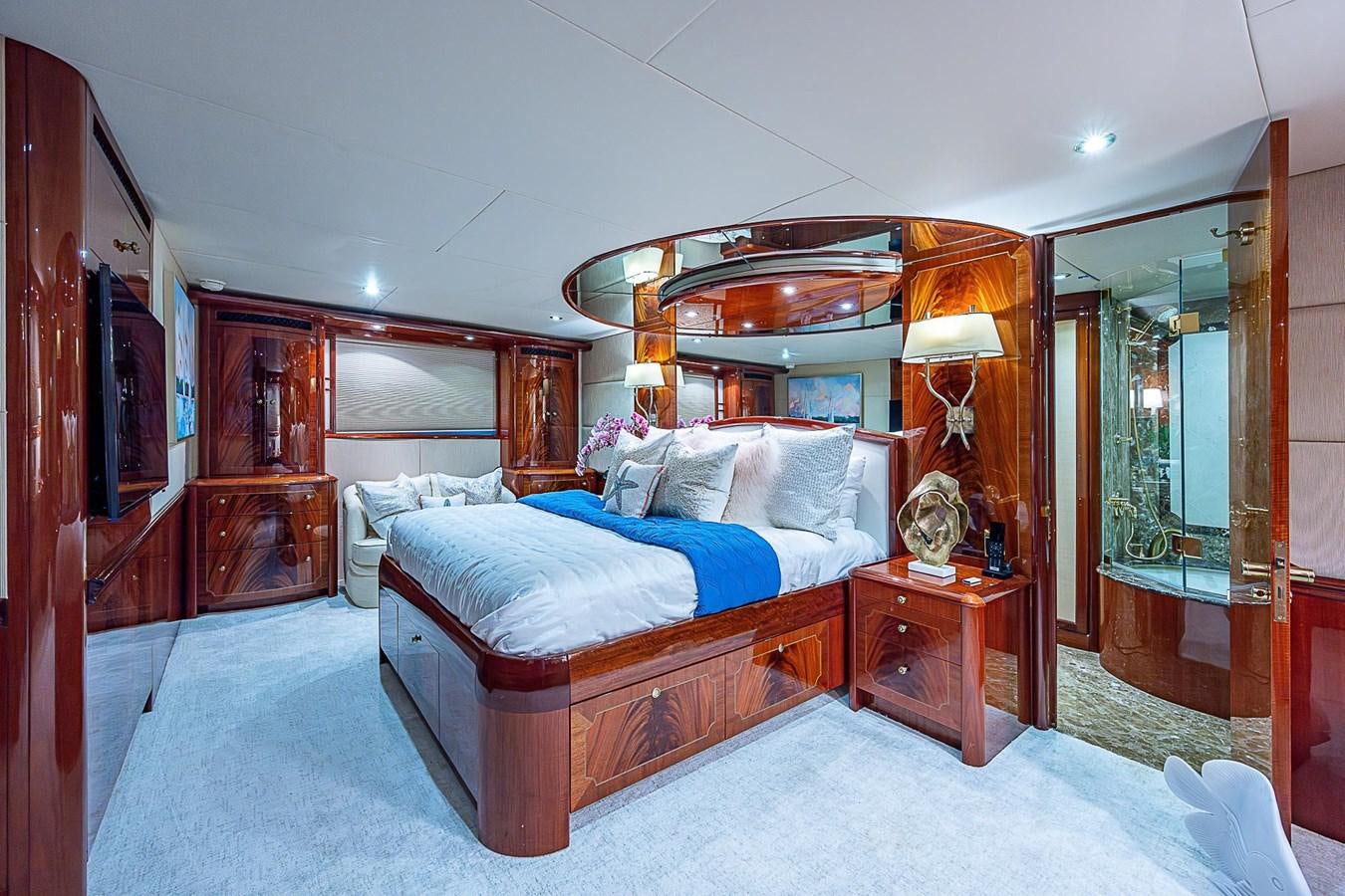 a bedroom with a bed and a mirror aboard LAZZARA 116 OPEN BRIDGE Yacht for Sale