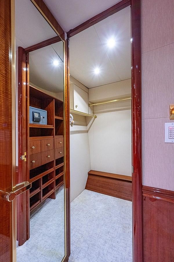 a room with a wood door and a television on the wall aboard LAZZARA 116 OPEN BRIDGE Yacht for Sale