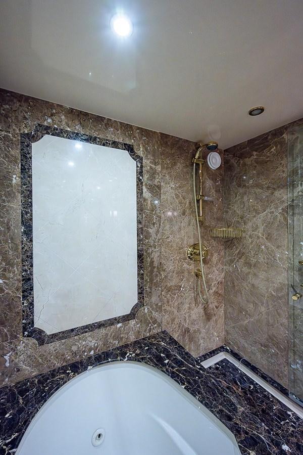 a bathroom with a tub and a mirror aboard LAZZARA 116 OPEN BRIDGE Yacht for Sale