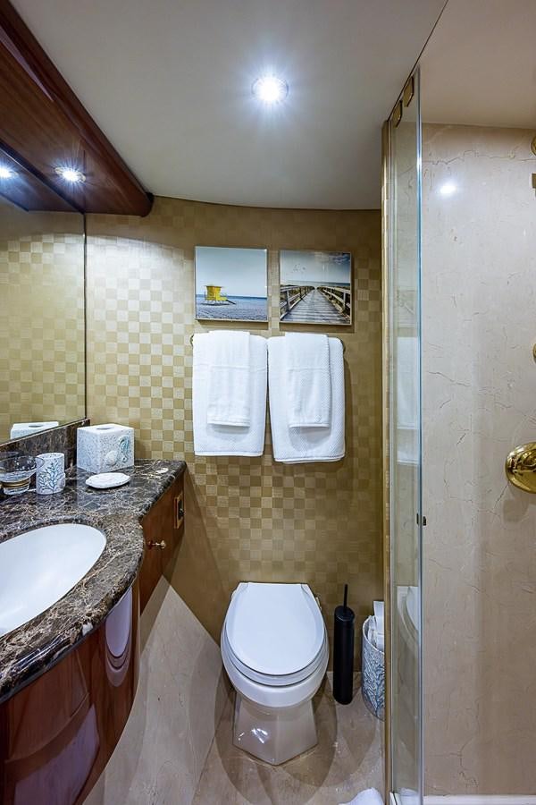 a bathroom with a sink toilet and a mirror aboard LAZZARA 116 OPEN BRIDGE Yacht for Sale