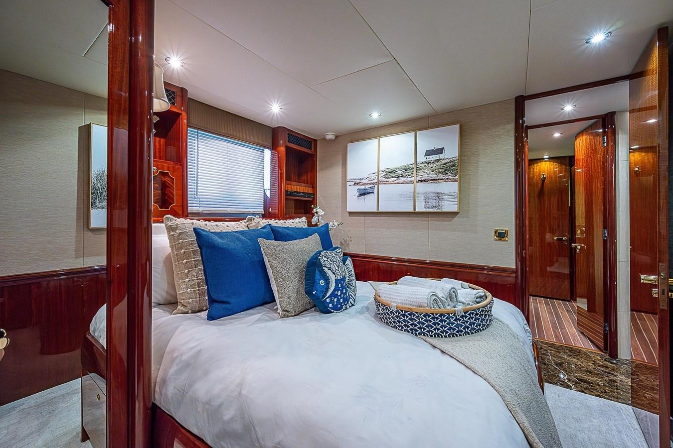 a bed with blue pillows aboard LAZZARA 116 OPEN BRIDGE Yacht for Sale