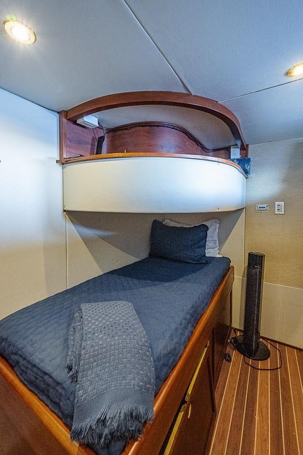 a bed with a wooden headboard aboard LAZZARA 116 OPEN BRIDGE Yacht for Sale