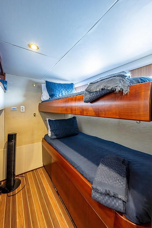 a bed with a blue comforter aboard LAZZARA 116 OPEN BRIDGE Yacht for Sale