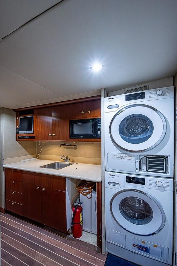 a washing machine in a kitchen aboard LAZZARA 116 OPEN BRIDGE Yacht for Sale