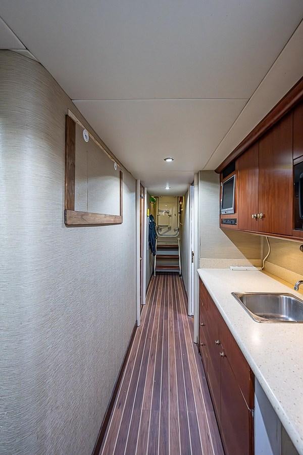 a long narrow hallway aboard LAZZARA 116 OPEN BRIDGE Yacht for Sale