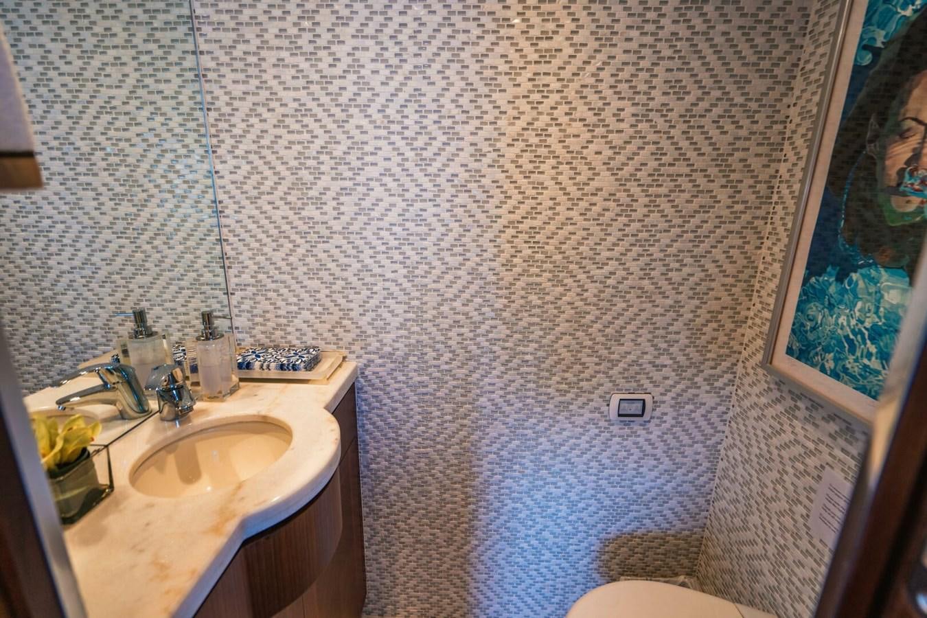 a bathroom with a sink and a painting on the wall aboard NEW ARRIVAL Yacht for Sale