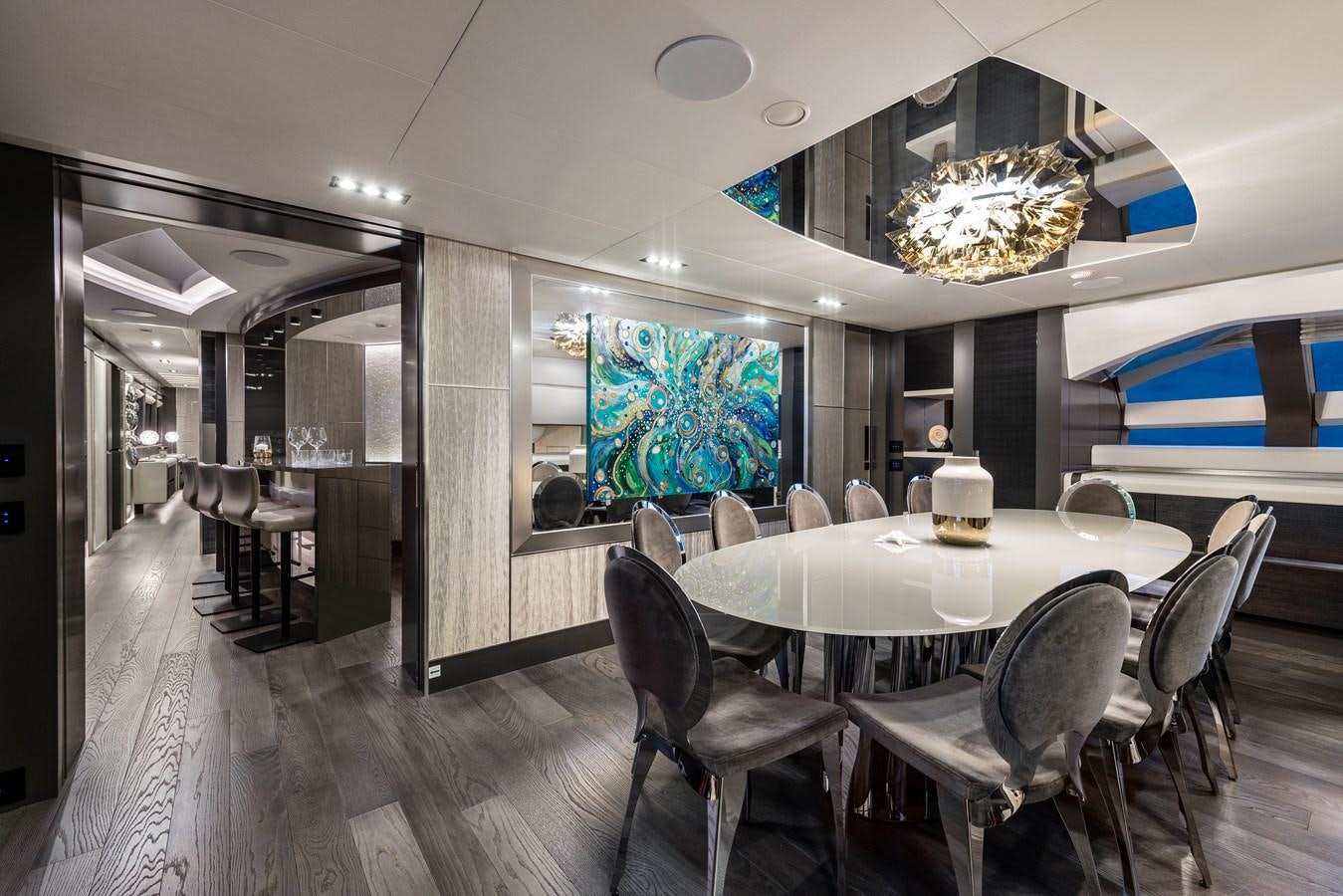 a room with a table chairs and a chandelier aboard CHORUSLINE Yacht for Sale