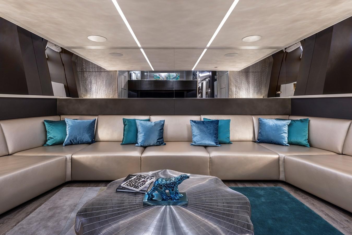 a couch with pillows and a table aboard CHORUSLINE Yacht for Sale