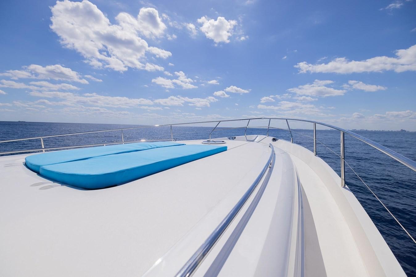 a road with a blue boat on it and blue sky and clouds aboard COOL BREEZE Yacht for Sale