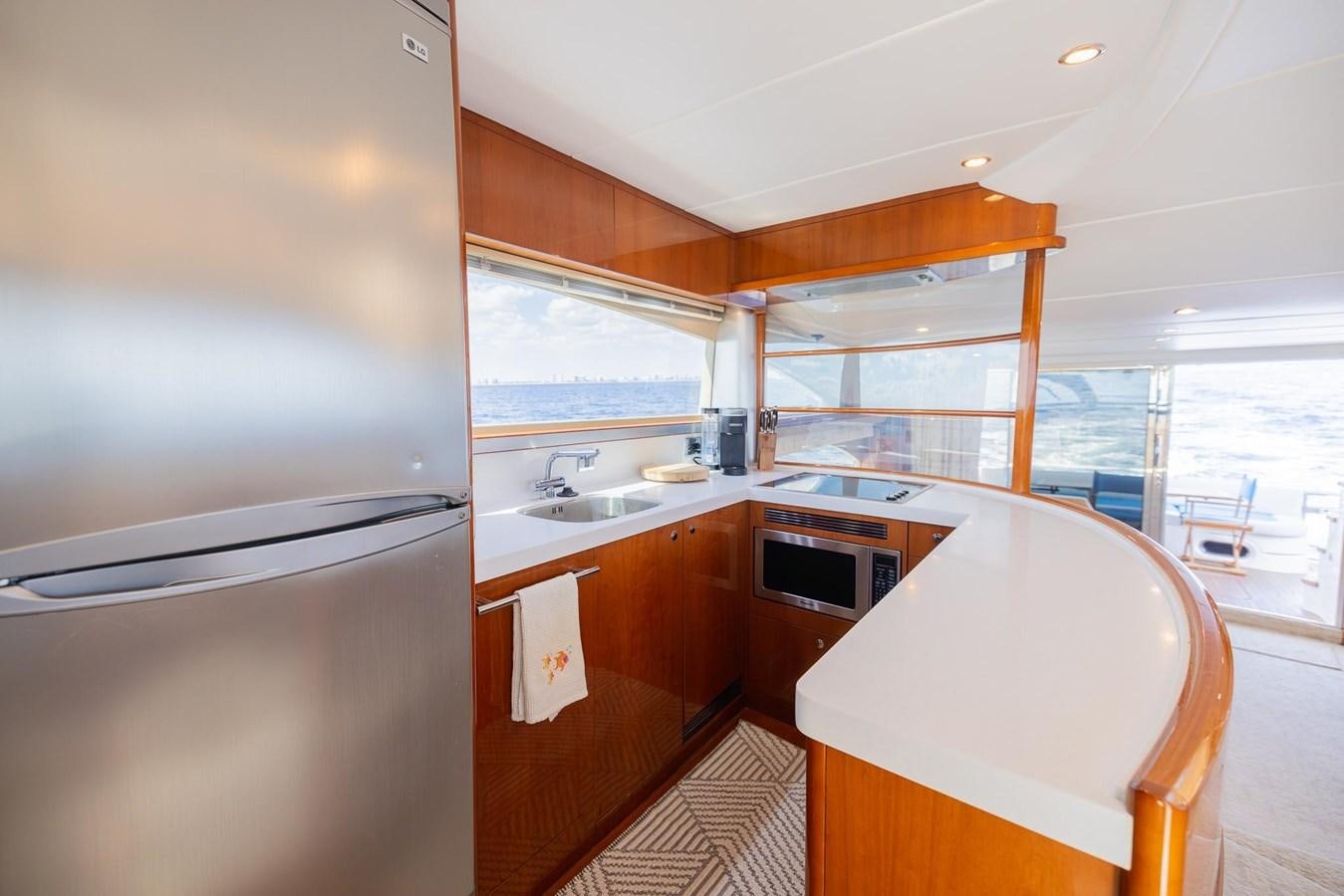 a kitchen with a refrigerator and a table aboard COOL BREEZE Yacht for Sale