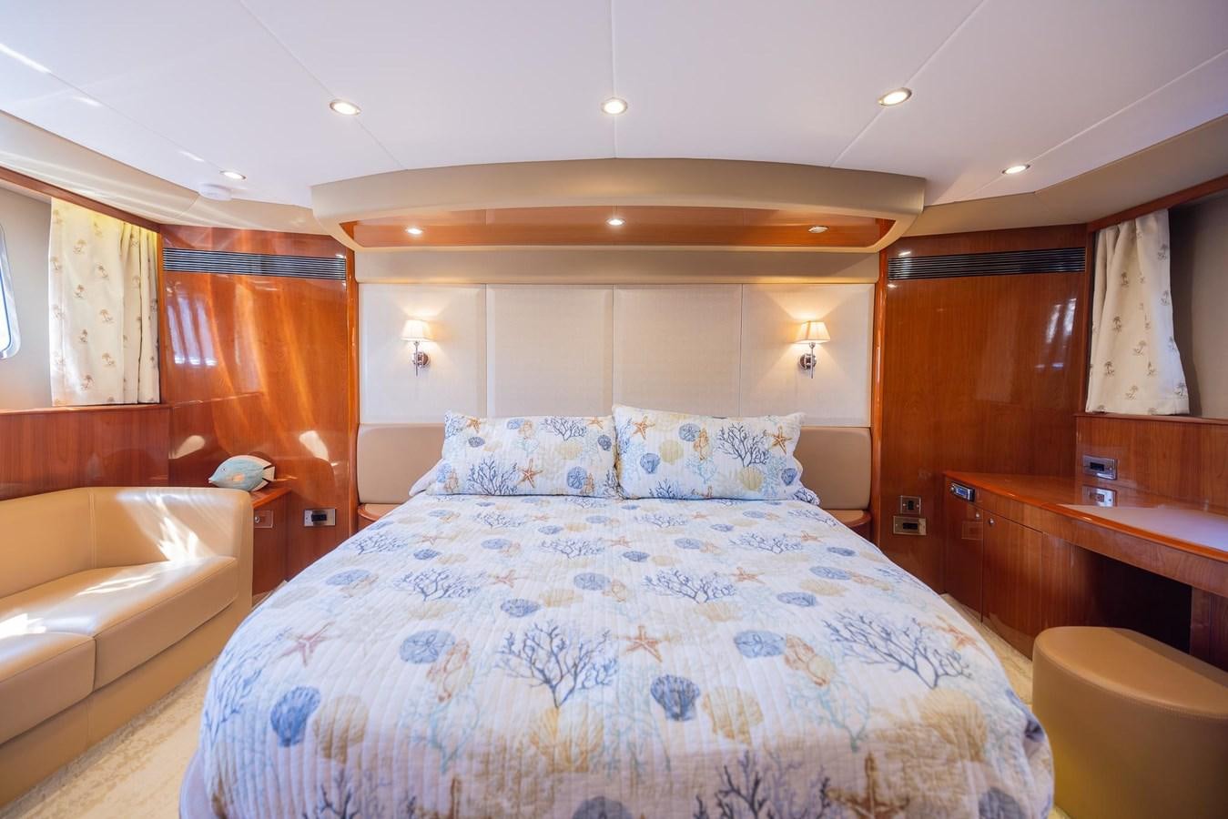a bedroom with a bed and a chair aboard COOL BREEZE Yacht for Sale
