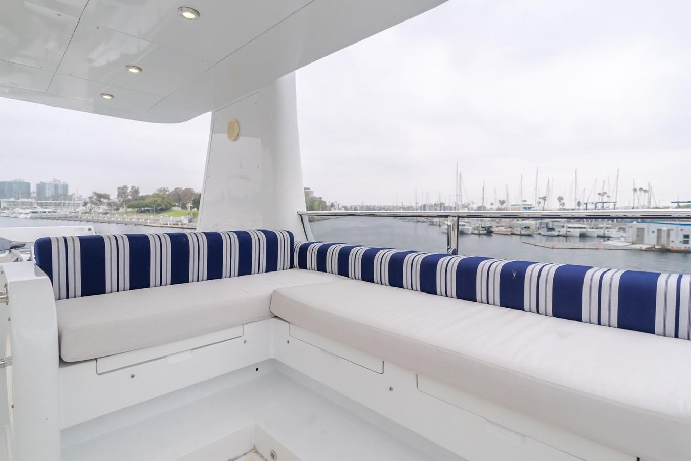 a row of white and blue striped seats on a boat aboard UNDAUNTED Yacht for Sale