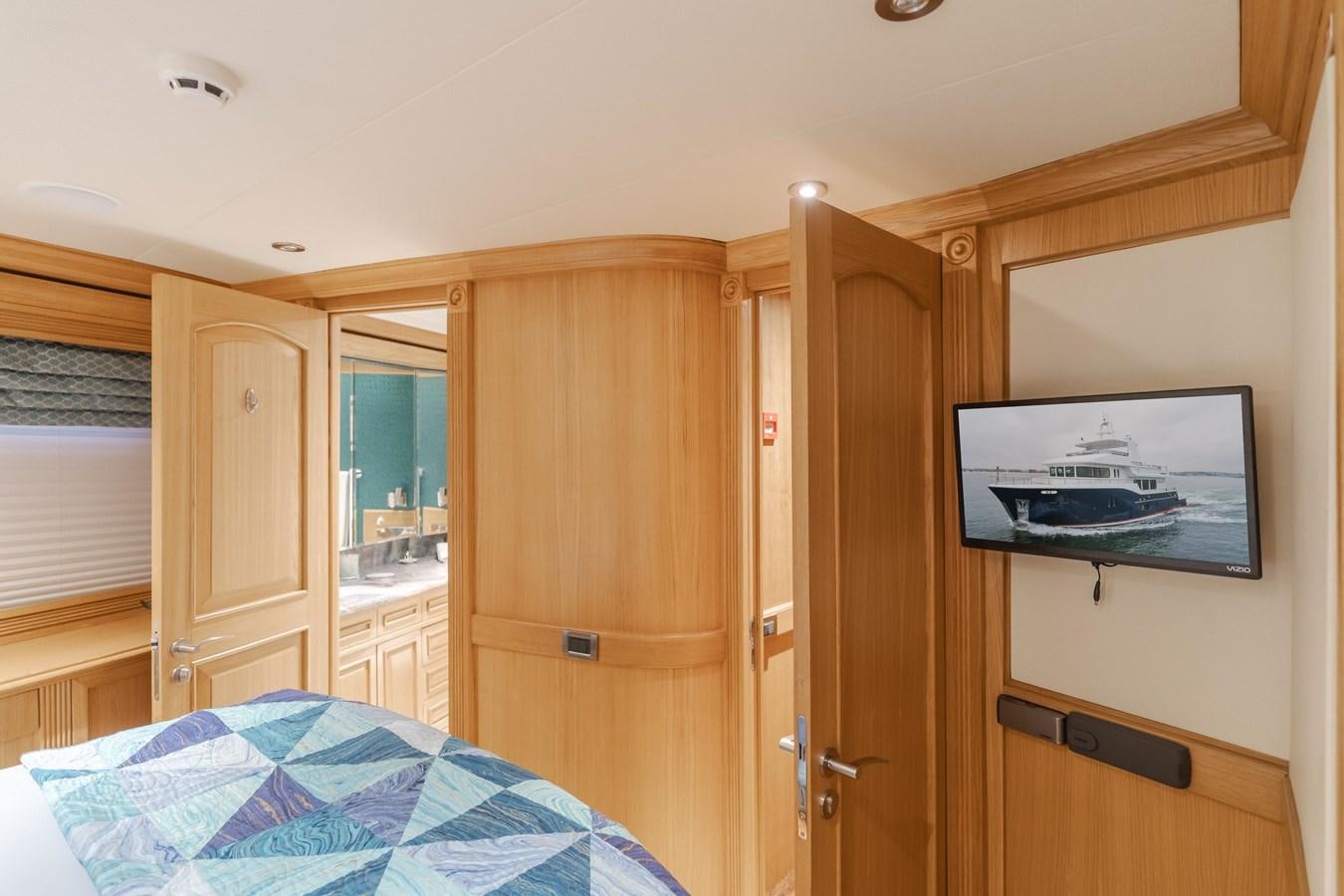 a bedroom with a bed and a television aboard UNDAUNTED Yacht for Sale