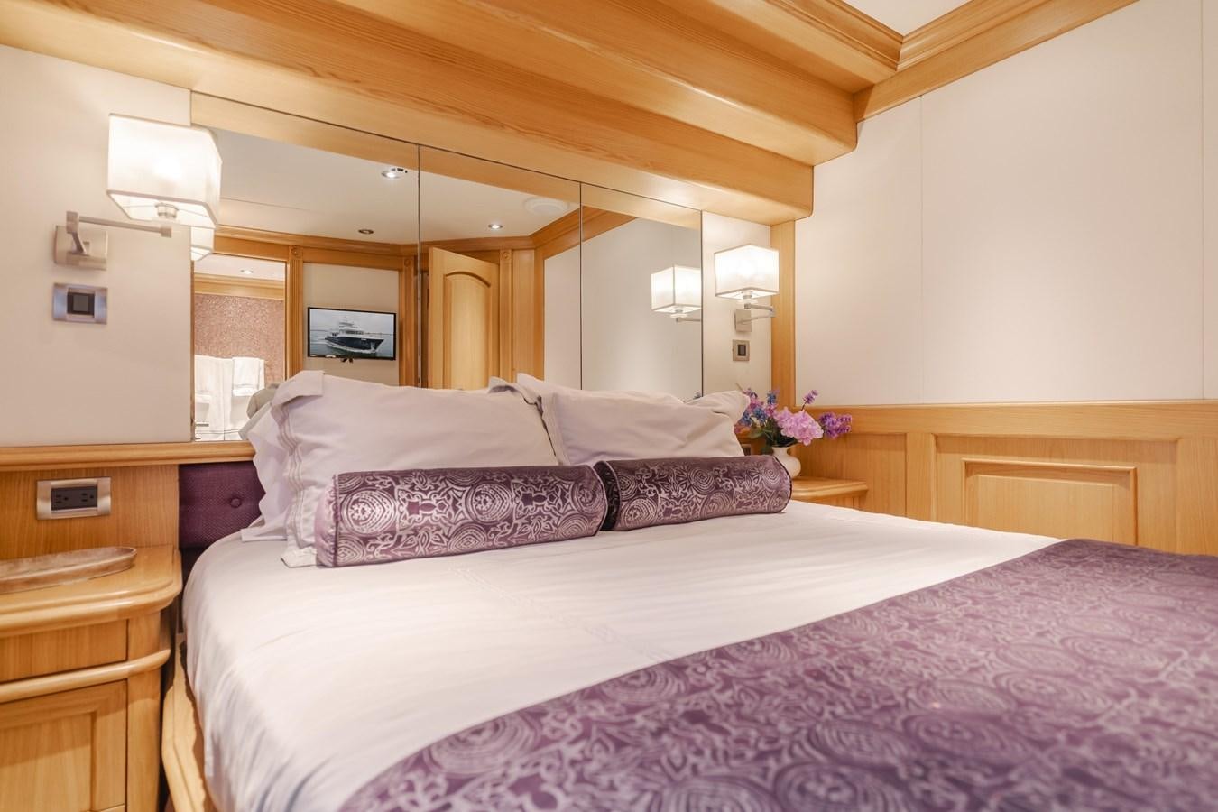 a bed with a purple comforter aboard UNDAUNTED Yacht for Sale