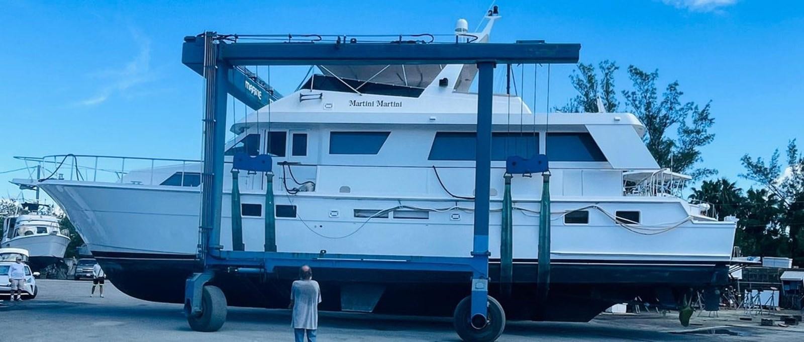a person standing next to a large white boat aboard MARTINI MARTINI Yacht for Sale