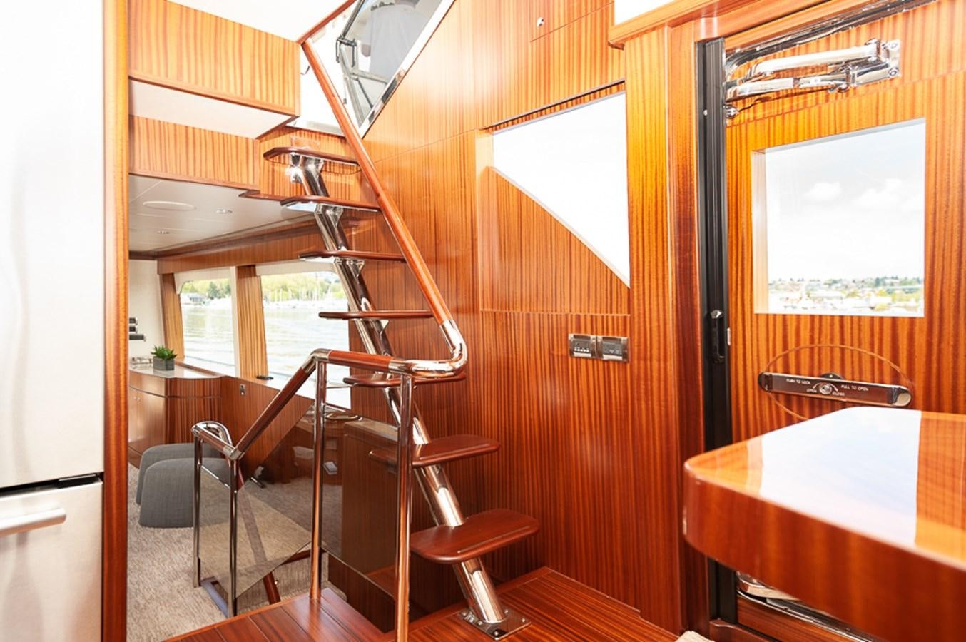 a wooden staircase with a table and chairs aboard FOREVER INTREPID Yacht for Sale