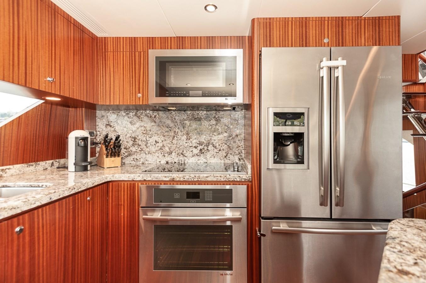 a kitchen with a stainless steel refrigerator aboard FOREVER INTREPID Yacht for Sale