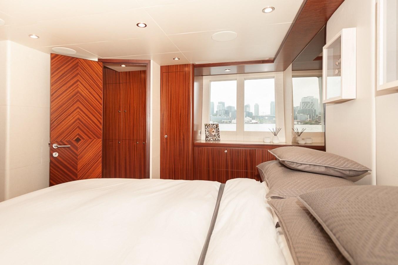 a bedroom with a bed and a door aboard FOREVER INTREPID Yacht for Sale
