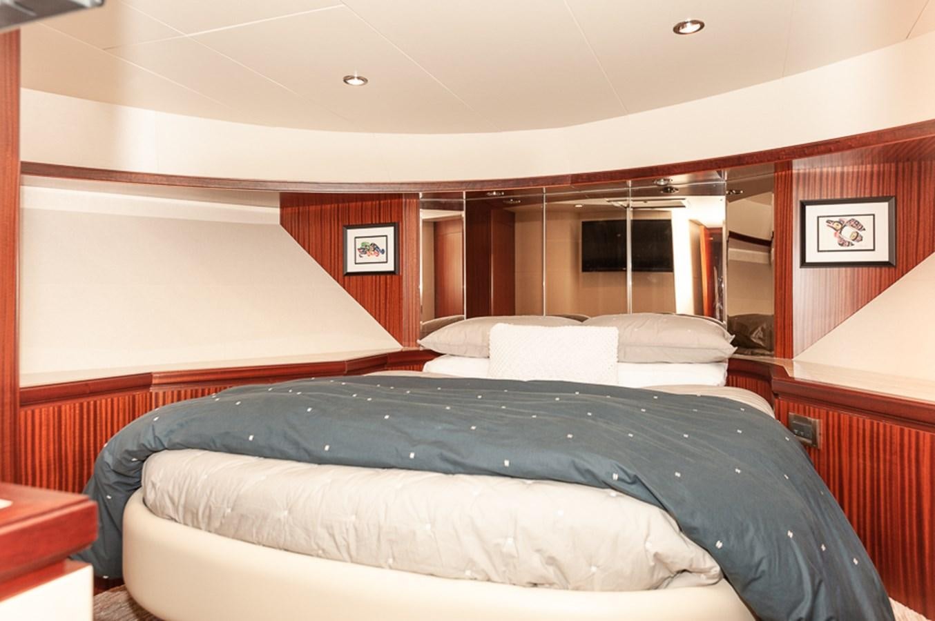 a room with a bed and a mirror aboard FOREVER INTREPID Yacht for Sale