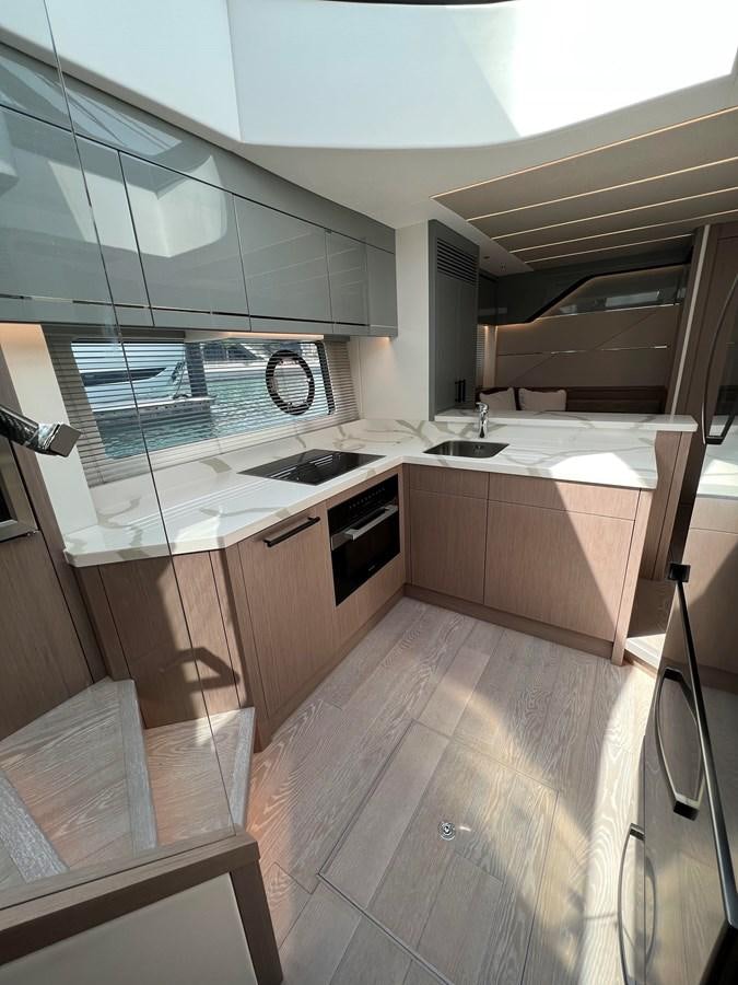 a kitchen with a stove and a sink aboard 2023 SUNSEEKER 65 SPORT Yacht for Sale