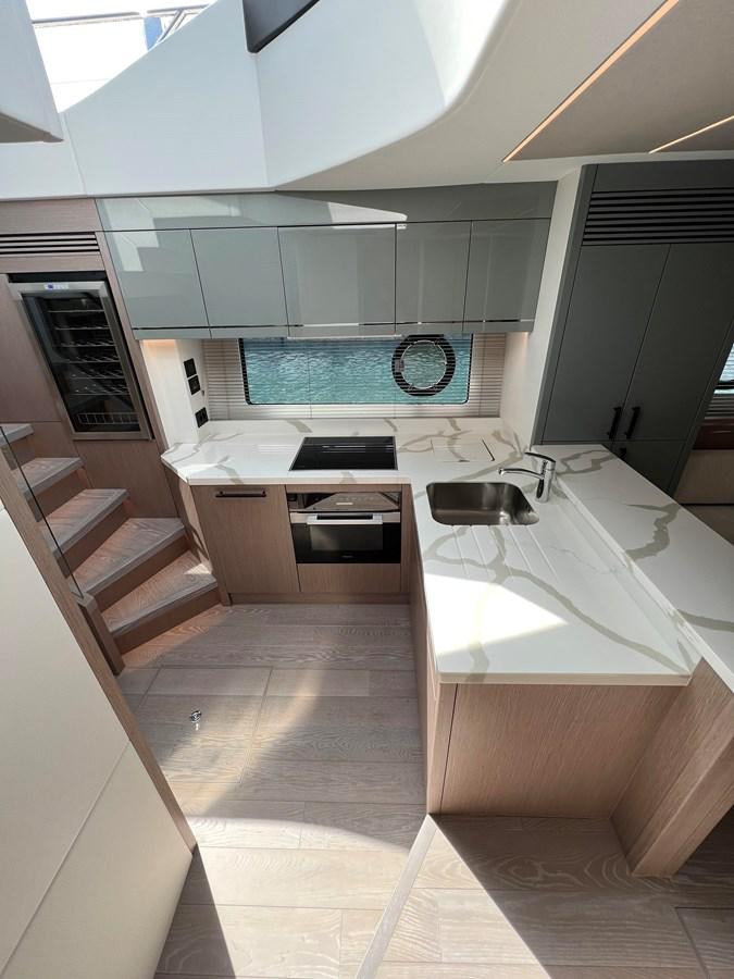 a kitchen with white cabinets aboard 2023 SUNSEEKER 65 SPORT Yacht for Sale