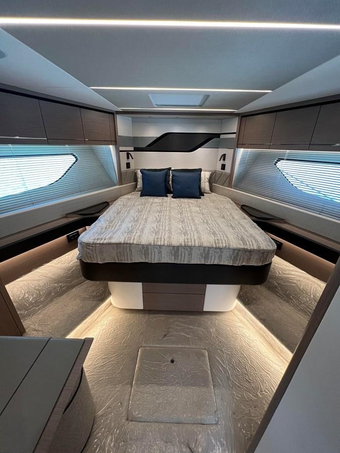 a room with a bed and a window aboard 2023 SUNSEEKER 65 SPORT Yacht for Sale