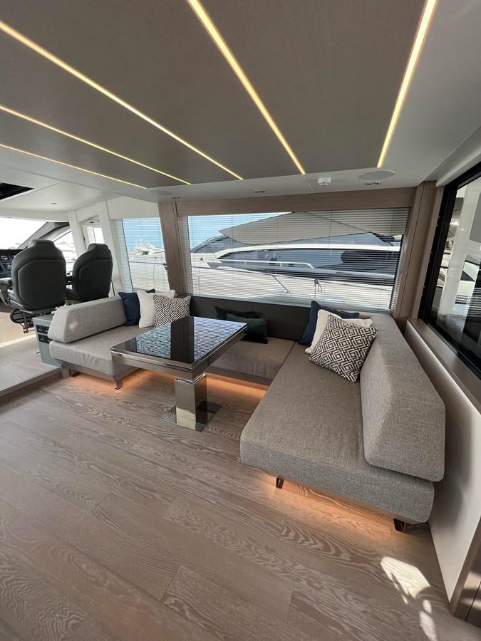 a living room with a large window aboard 2023 SUNSEEKER 65 SPORT Yacht for Sale