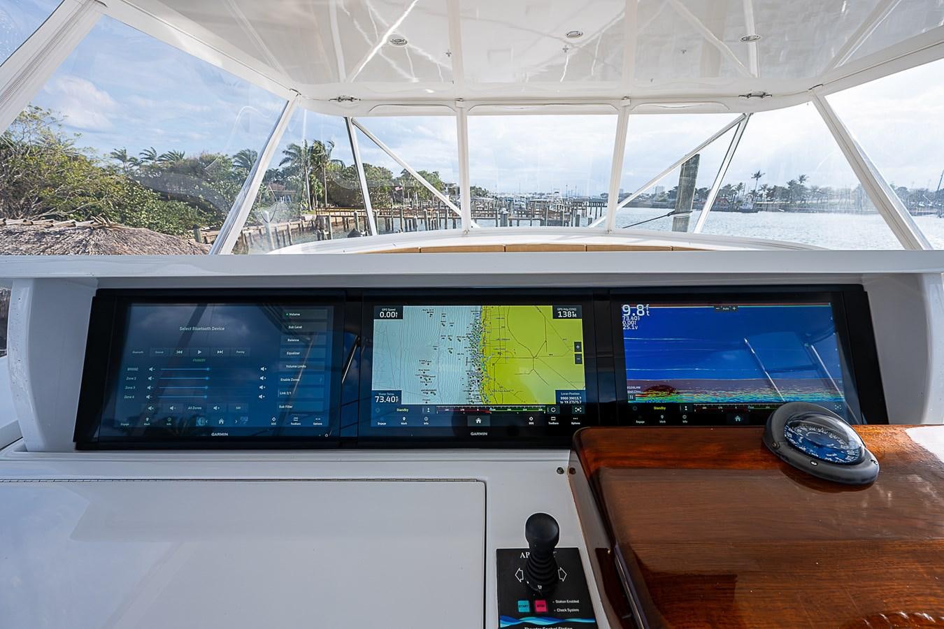 a computer monitor and keyboard on a desk in a room with a window aboard INSTIGATOR Yacht for Sale