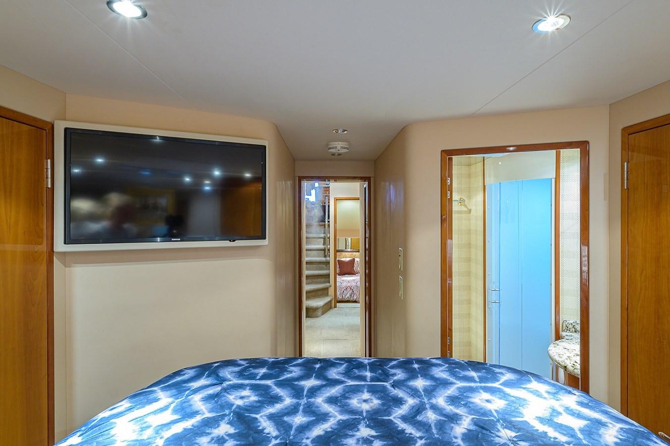 a bedroom with a television on the wall aboard INSTIGATOR Yacht for Sale