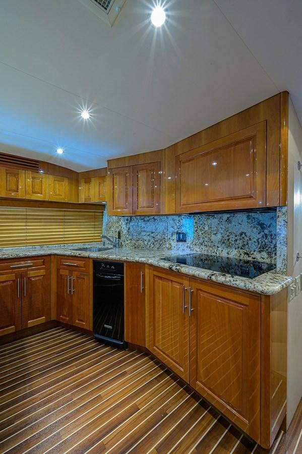 a kitchen with wooden cabinets aboard INSTIGATOR Yacht for Sale