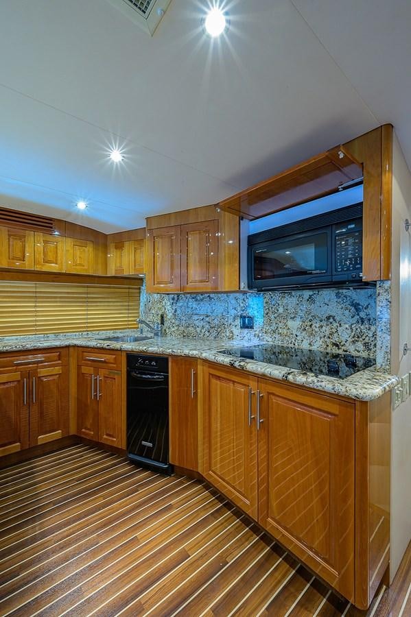 a kitchen with wooden cabinets aboard INSTIGATOR Yacht for Sale